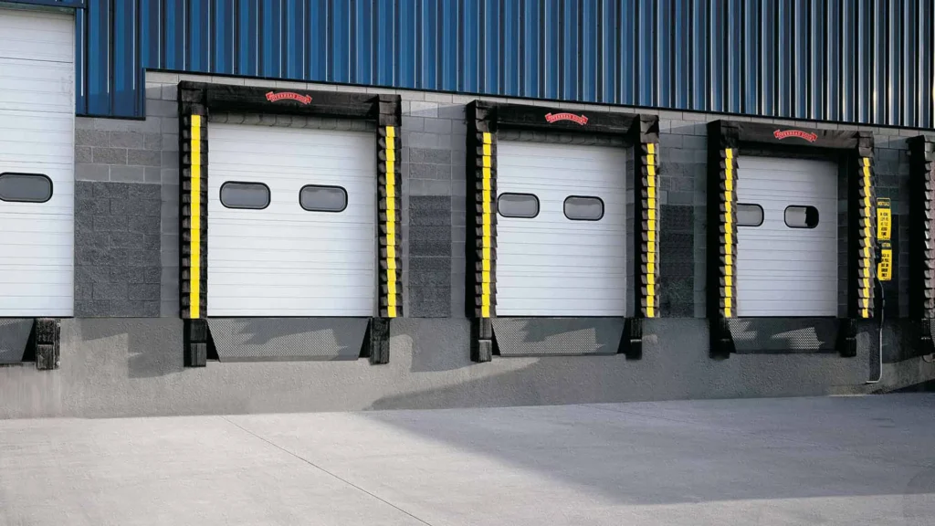 Loading dock with three overhead doors featuring safety bumpers, designed for efficient cargo handling in commercial and industrial settings.