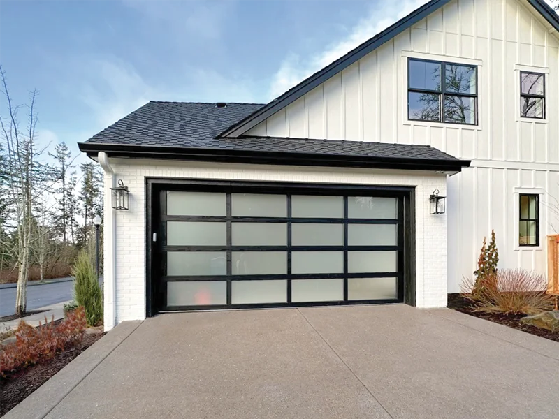 Contemporary black and frosted glass garage door on modern white house, showcasing stylish residential entry solution.