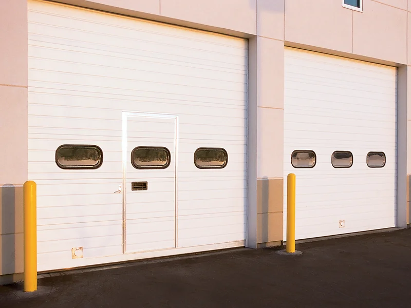 Commercial garage doors with windows and a side access door, designed for reliability and safety in business operations.