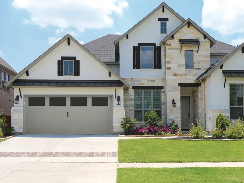 Modern residential home with a stylish garage door, landscaped front yard, and inviting entrance, representing quality garage door solutions by Overhead Door Company of Fresno.