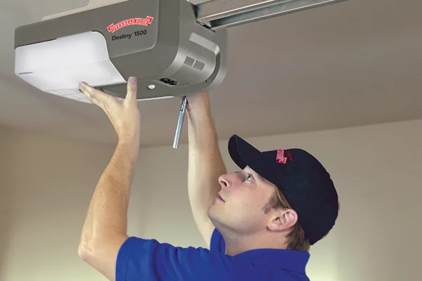 Technician installing a Destiny 1500 garage door opener, ensuring proper functionality and safety for residential garage door systems.